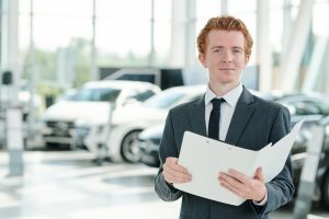 Young-serious-manager-of-contemporary-car-center-holding-open-folder