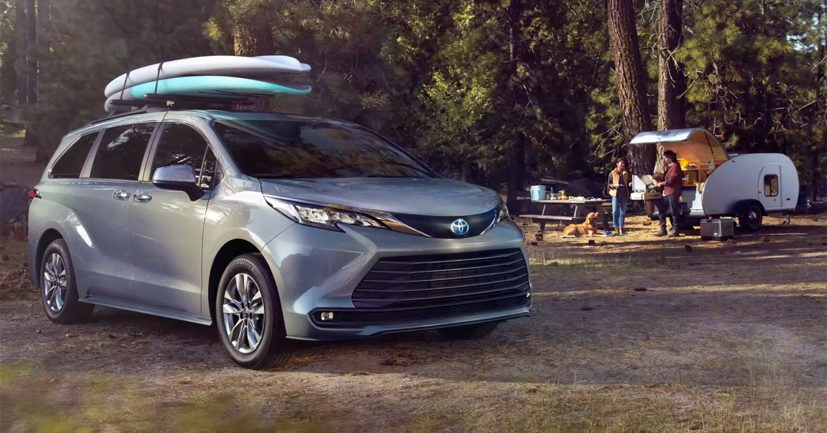 2023 Toyota Sienna with Surfboards on top and trailer in the background