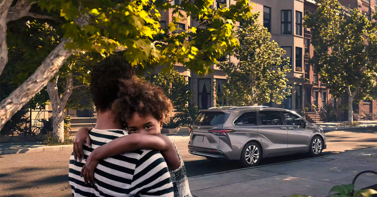 2023 Toyota Sienna with person carrying a child towards it