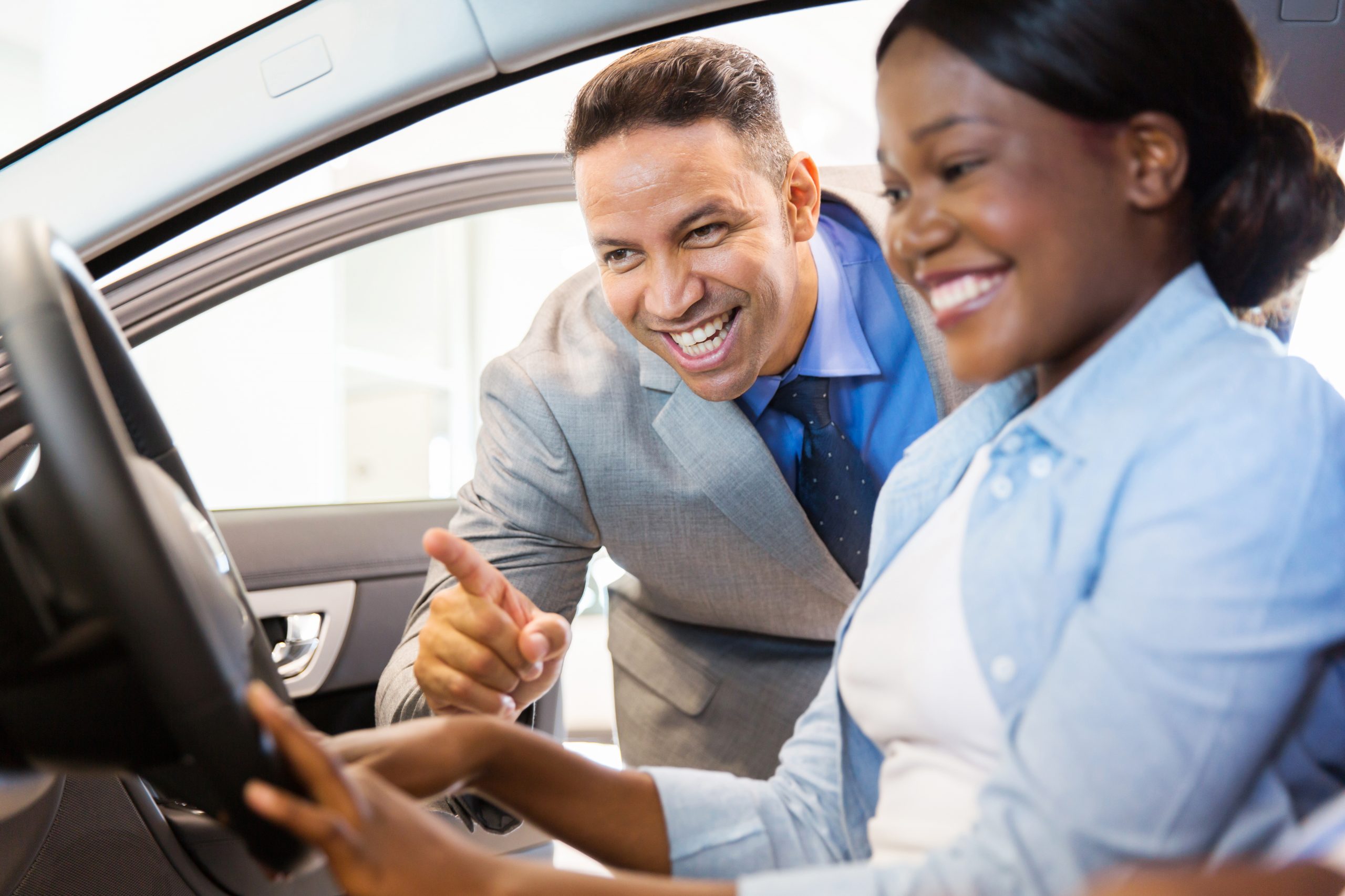 Salesman showing woman features in a car