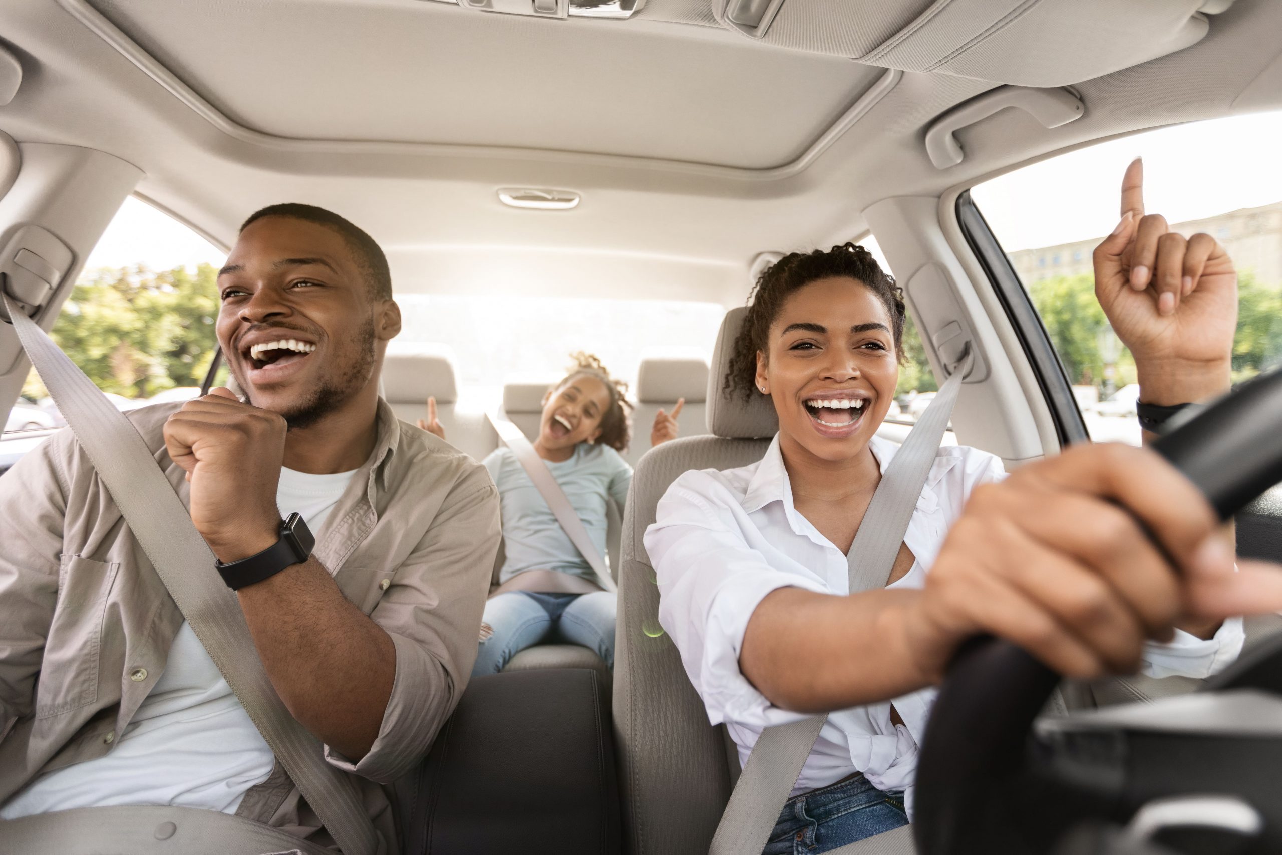 Family happily test driving a car