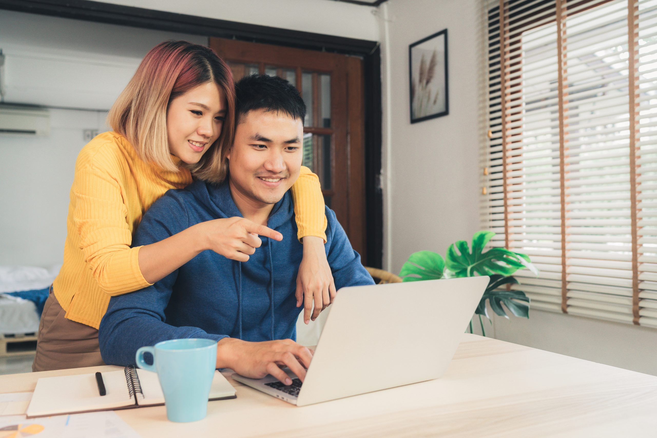 Couple at their laptop with woman pointing at the screen