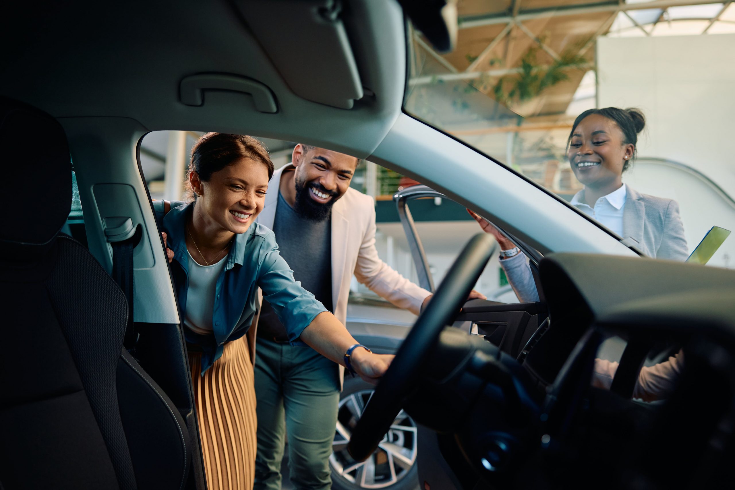 Woman and man looking inside a car door