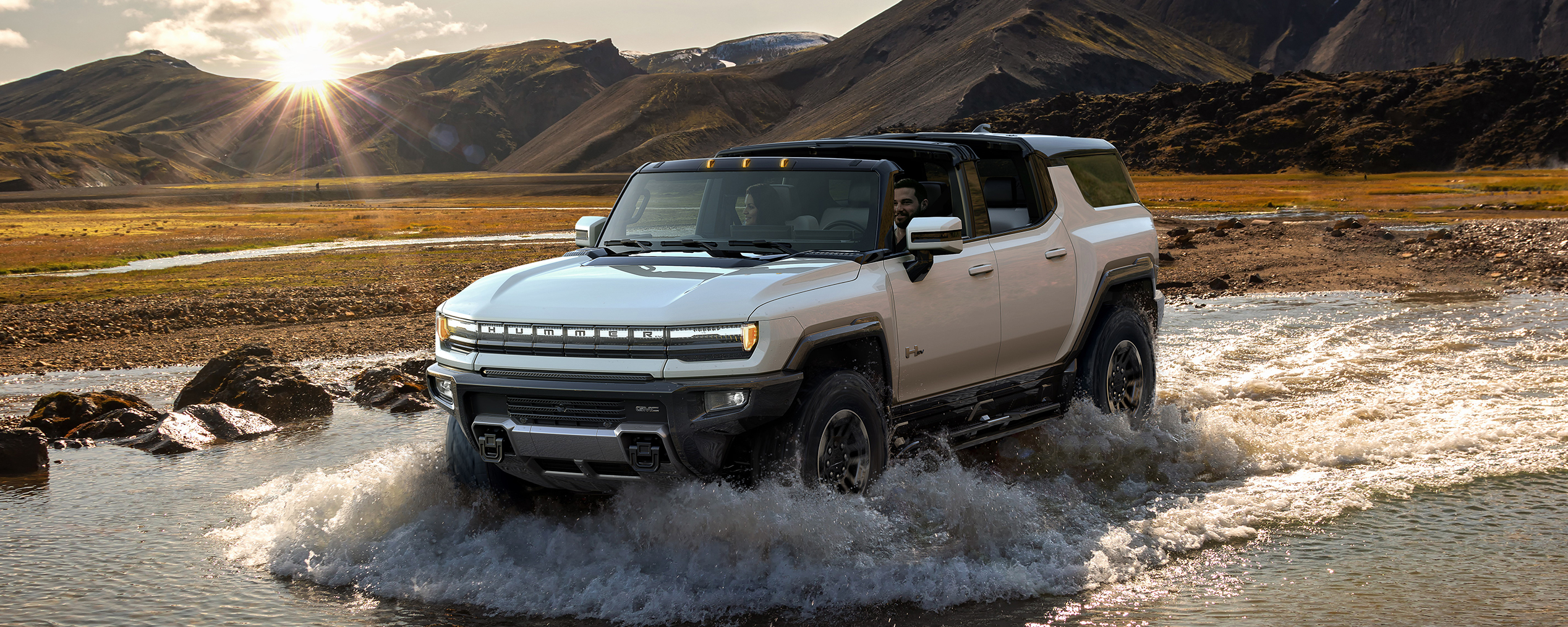 2024 Hummer EV driving through shallow water