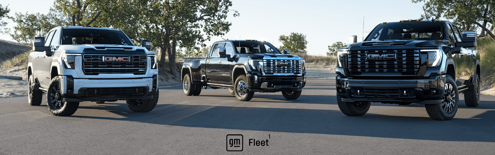 Two GMC fleet vehicles at a work site