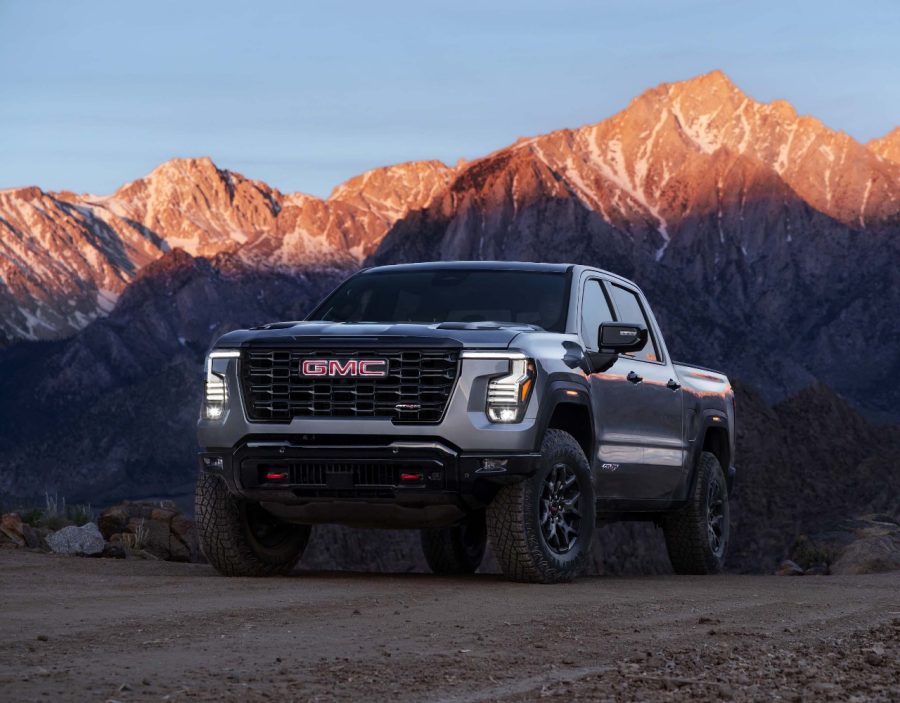 Silver 2027 GMC Sierra 1500 AT4 parked on a rocky desert trail with mountains in the background